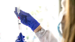 A nurse preparing an IV for the sedation of a dental patient.
