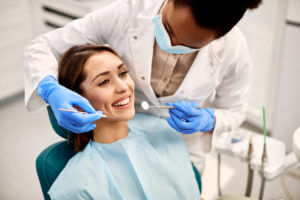 Young happy woman during dental procedure at dentist's office