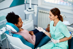dentist and her black female patient talking at dental clinic