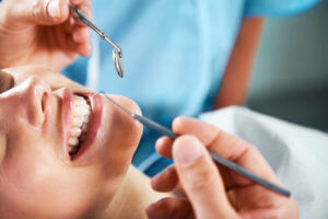 Cropped image of a young woman smiling widely while undergoing a dental procedure