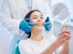Shot of a young woman checking her Dental Cleaning results in the dentists office