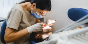 Orthodontist making treatment in modern clinic for man