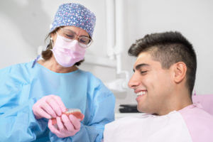Cosmetic Dentistry- Orthodontist holding invisible retainer for teeth alignment