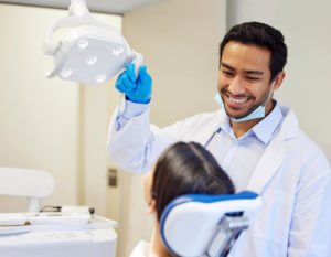 Shot of a young male dentist getting ready to conduct a procedure on his female patient for dental care.