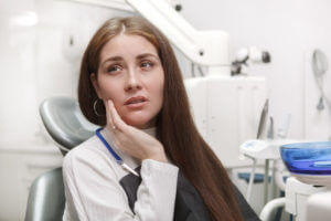 Image of a female patient at an emergency dental clinic due to tooth pain seeking emergency dental treatment.