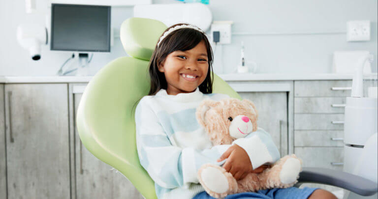 child with a toy and stuffed animal with checkup and appointment with dental care