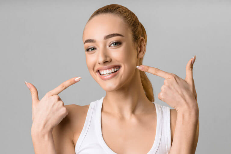 Happy lady showing her beaming white teeth.